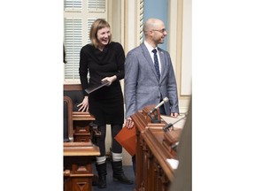 Quebec Solidaire MNAs Catherine Dorion, left, and Sol Zanetti smile as they enter for question period, Wednesday, December 5, 2018 at the legislature in Quebec City. Some concerns were raised the last days on the dress code from the two MNAs