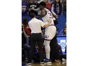 Kansas center Udoka Azubuike (35) is aided by training staff after an injury during the first half of an NCAA college basketball game against Wofford in Lawrence, Kan., Tuesday, Dec. 4, 2018.