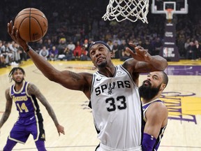 San Antonio Spurs forward Dante Cunningham, center, shoots as Los Angeles Lakers forward Brandon Ingram, left, and center Tyson Chandler defend during the first half of an NBA basketball game Wednesday, Dec. 5, 2018, in Los Angeles.