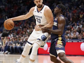 Memphis Grizzlies center Marc Gasol (33) is guarded by New Orleans Pelicans guard Jrue Holiday (11) in the first half of an NBA basketball game in New Orleans, Friday, Dec. 7, 2018.