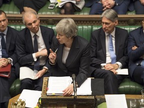 Britain's Prime Minister Theresa May, centre, gives a reply to lawmakers during the scheduled Prime Minister's Questions time, in the House of Commons, London, Wednesday Dec. 5, 2018. Britain's House of Commons opened round two Wednesday in a bruising battle between lawmakers and Prime Minister Theresa May's government over Britain's Brexit split with the EU.
