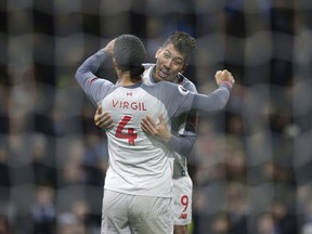 Liverpool's Roberto Firmino celebrates scoring his side's second goal of the game with team-mate Virgil van Dijk, during their English Premier League soccer match at Turf Moor in Burnley, England, Wednesday Dec. 5, 2018.