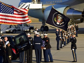The flag-draped casket of former President George H.W. Bush is carried by a joint services military honor guard to a hearse at Andrews Air Force Base in Md., Monday, Dec. 3, 2018.