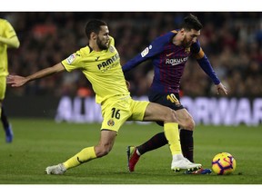 FC Barcelona's Lionel Messi, right, duels for the ball with Villarreal's Santiago Pedraza during the Spanish La Liga soccer match between FC Barcelona and Villarreal at the Camp Nou stadium in Barcelona, Spain, Sunday, Dec. 2, 2018.