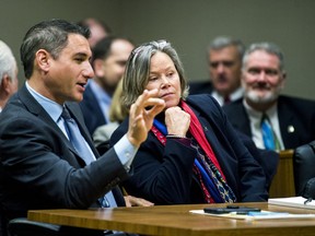 Defense attorney Steve Tramontin speaks with his client Dr. Eden Wells before a hearing Friday, Dec. 7, 2018, at Genesee District Court in downtown Flint, Mich. Wells, Michigan's chief medical executive, will stand trial on involuntary manslaughter and other charges in a criminal investigation of the Flint water crisis, a judge ruled Friday.