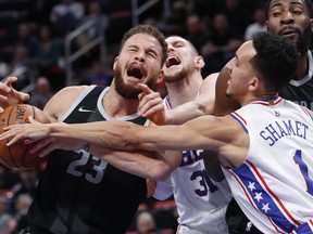 Detroit Pistons forward Blake Griffin (23) is fouled by Philadelphia 76ers forward Mike Muscala (31) as Landry Shamet (1) defends in the first half of an NBA basketball game in Detroit, Friday, Dec. 7, 2018.