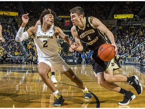 Michigan forward Ignas Brazdeikis (13) dunks the ball, watched by Purdue guard Carsen Edwards (3), in the first half of an NCAA college basketball game at Crisler Center in Ann Arbor, Mich., Saturday, Dec. 1, 2018.