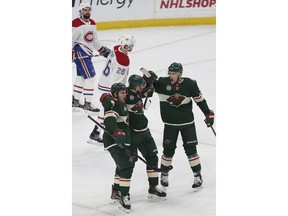 Minnesota Wild's Nino Niederreiter of Switzerland, middle, celebrates with teammates Zach Parise, left, and Charlie Coyle, right, after Niederreiter scored a goal against the Montreal Canadiens in the first period of an NHL hockey game Tuesday, Dec. 11, 2018, in St. Paul, Minn.