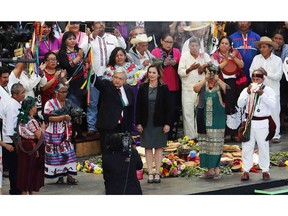 Mexico's new President Andres Manuel Lopez Obrador, center, participates in a traditional indigenous ceremony at the Zocalo, in Mexico City, Saturday, Dec. 1, 2018. Mexicans are getting more than just a new president Saturday. The inauguration of Lopez Obrador will mark a turning point in one of the world's most radical experiments in opening markets and privatization