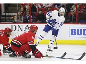 Toronto Maple Leafs' Nazem Kadri (43) passes the puck while Carolina Hurricanes' Jaccob Slavin (74) and Dougie Hamilton (19) block during the first period of an NHL hockey game in Raleigh, N.C., Tuesday, Dec. 11, 2018.