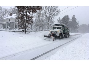 A snow plow moves on a snowy Durham, N.C., street after several inches fell on Sunday Dec. 9, 2018. A storm spreading snow, sleet and freezing rain across a wide swath of the South has millions of people in its path, raising the threat of immobilizing snowfalls, icy roads and possible power outages.