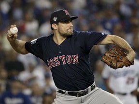 FILE - In this Oct. 26, 2018, file photo, Boston Red Sox starting pitcher Nathan Eovaldi throws against the Los Angeles Dodgers during the 12th inning in Game 3 of the World Series baseball game in Los Angeles. Eovaldi's marathon relief performance in Game 3 is a moment that will resonate in Red Sox history. Boston rewarded him with a $68 million, four-year contract.