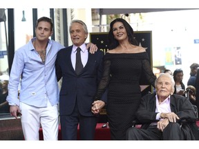 FILE - In this Nov. 6, 2018, file photo, Honoree and actor Michael Douglas, second left, poses with his father actor Kirk Douglas, from right, wife Catherine Zeta-Jones and son Cameron Douglas following a ceremony honoring him with a star on the Hollywood Walk of Fame in Los Angeles. Kirk Douglas celebrated his 102nd birthday with a special video message from his daughter-in-law. Catherine Zeta-Jones posted the video on Instagram Sunday, Dec. 9.