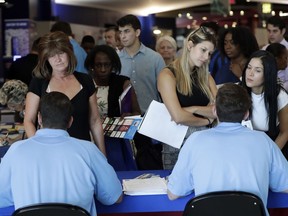 FILE- In this June 21, 2018 file photo, job applicants talks with representatives from Aldi at a job fair hosted by Job News South Florida, in Sunrise, Fla. On Thursday, Dec. 6, payroll processor ADP reports how many jobs private employers added in November.