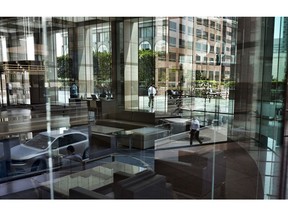 FILE- In this Aug. 27, 2018, file photo buildings and officer workers are reflected on windows in downtown Los Angeles. General Motors' plans to cut more than 8,000 white-collar workers are a warning that few jobs are safe. Experts say technology is changing so fast that most workers will have to train for several careers during their lifetimes.