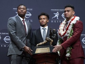 Heisman Trophy finalists, from left, Dwayne Haskins, from Ohio State; Kyler Murray, from Oklahoma; and Tua Tagovailoa, from Alabama, pose with the trophy during a media event Saturday, Dec. 8, 2018, in New York.