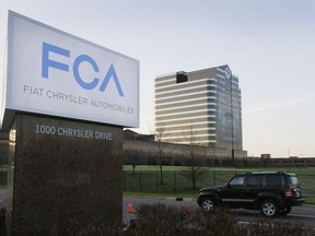 FILE - In this May 6, 2014, file photo, a vehicle moves past a sign outside Fiat Chrysler Automobiles world headquarters in Auburn Hills, Mich. Fiat Chrysler will open another assembly plant in the Detroit area, according to a person familiar with the automaker's plan. The source said the plant will produce SUVs but did not specify when it will open or how many jobs it will create. The person spoke on condition of anonymity because the plan has not been made public. Fiat Chrysler declined to comment Thursday, Dec. 6, 2018.