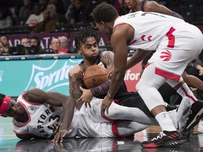 Brooklyn Nets guard D'Angelo Russell, center, vies for the ball against Toronto Raptors forward Pascal Siakam (43) and guard Kyle Lowry (7) during the second half of an NBA basketball game, Friday, Dec. 7, 2018, in New York.