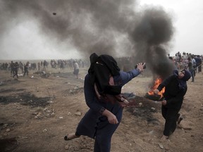 Palestinian women hurl stones at Israeli troops during a protest at the Gaza Strip's border with Israel on May 4, 2018.