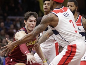 Cleveland Cavaliers' Cedi Osman, left, passes the ball past Washington Wizards' Bradley Beal during the first half of an NBA basketball game Saturday, Dec. 8, 2018, in Cleveland.