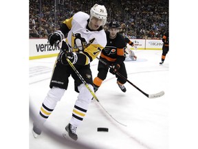 Pittsburgh Penguins' Evgeni Malkin (71) knocks the puck out of the air with Shayne Gostisbehere (53) defending during the second period of an NHL hockey game in Pittsburgh, Saturday, Dec. 1, 2018.