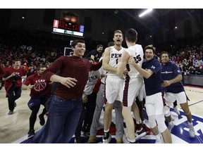 Penn's Max Rothschild (0) and AJ Brodeur (25) celebrate as students storm the court after Penn beat Villanova, 78-75, in an NCAA college basketball game, Tuesday, Dec. 11, 2018, in Philadelphia.