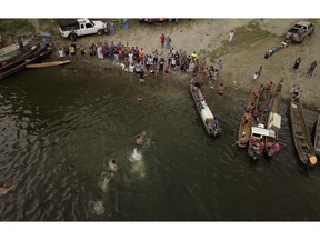 In this Nov. 25, 2018 photo, indigenous men finish the swimming competition during the second edition of the Panamanian indigenous games on lake Bayano, Panama. In terms of surface area, Lake Bayano is the second largest lake in Panama, exceeded only by Lake Gatun.