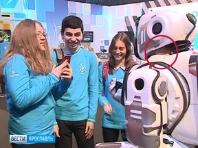 The "robot," complete with very human neck, chats with kids at the tech expo.