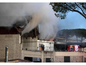 Firefighters work to estinguish a fire which broke out overnight at a garbage deposit on the outskirts of Rome, Tuesday, Dec. 11, 2018. The cloud of smoke was visible above Rome's skyline, no injuries were reported.