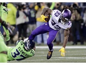 Minnesota Vikings' Dalvin Cook runs with the ball as Seattle Seahawks' Tre Flowers tries to bring him down in the first half of an NFL football game, Monday, Dec. 10, 2018, in Seattle.
