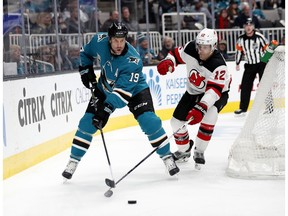 San Jose Sharks' Joe Thornton (19) battles for the puck against New Jersey Devils' Ben Lovejoy (12) in the first period of an NHL hockey game in San Jose, Calif., Monday, Dec. 10, 2018.