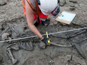 An archaelogists measures a 500-year-old medieval skeleton found in the Thames Tideway tunnel, excavated to divert sewage away from the river.