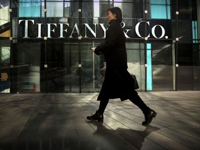 In this Thursday, Nov. 29, 2018, photo, a woman walks past a Tiffany & Co. store at a shopping mall in Beijing. The designer boutiques of Manhattan and Paris are feeling the chill of a Chinese economic slowdown that has hammered automakers and other industries. That is jolting brands such as Louis Vuitton and Burberry that increasingly rely on Chinese customers who spend $90 billion a year on jewelry, clothes and other high-end goods. The industry already is facing pressure to keep up as China's big spenders shift to buying more at the spreading networks of luxury outlets in their own country.