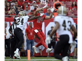 Tampa Bay Buccaneers tight end Cameron Brate (84) pulls in an 11-yard touchdown reception in front of New Orleans Saints strong safety Vonn Bell (24) during the first half of an NFL football game Sunday, Dec. 9, 2018, in Tampa, Fla.