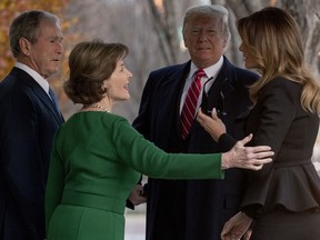 President Donald Trump, second from right, and first lady Melania Trump, right, are greeted by former President George Bush and former first lady Laura Bush outside the Blair House across the street from the White House in Washington, Tuesday, Dec. 4, 2018.