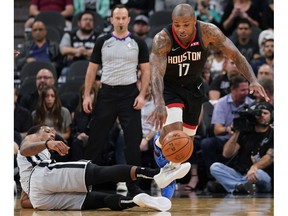 Houston Rockets' P.J. Tucker (17) falls as he is fouled by San Antonio Spurs' DeMar DeRozan during the first half of an NBA basketball game Friday, Nov. 30, 2018, in San Antonio.