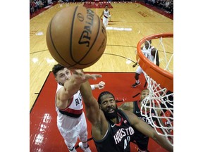 Houston Rockets' Nene Hilario (42) and Portland Trail Blazers' Jusuf Nurkic reach for a rebound during the first half of an NBA basketball game Tuesday, Dec. 11, 2018, in Houston.