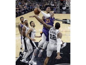 Phoenix Suns forward Richaun Holmes (21) drives to the basket against San Antonio Spurs forward LaMarcus Aldridge (12) during the first half of an NBA basketball game, Tuesday, Dec. 11, 2018, in San Antonio.