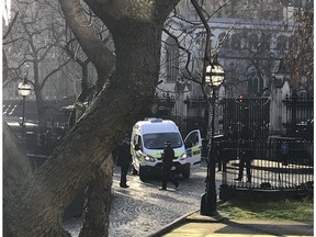 Police attend the scene after a man is held by armed police inside the Palace of Westminster, Tuesday Dec. 11, 2018. A man could be seen being held against a fence inside the main gate to Britain's Parliament.