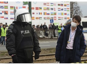 A climate conference participant looks at a police officer during the March for Climate, a protest against global warming in Katowice, Poland, Saturday, Dec. 8, 2018, as the COP24 UN Climate Change Conference takes place in the city.
