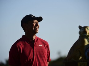 U.S. golfer Tiger Woods stands near the Hero World Challenge trophy before presenting it to Spain's Jon Rahm at Albany Golf Club in Nassau, Bahamas, Sunday, Dec. 2, 2018.