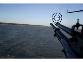 A helicopter's machine gun is turned toward the sea shore during patrol near Urzuf, south coast of Azov sea, eastern Ukraine, Thursday, Nov. 29, 2018.