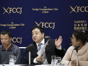 In this Nov. 28, 2018, photo, lawyer Shoichi Ibusuki, center, speaks during a press conference in Tokyo, on the problems in Japan's technical intern program, with Eng Pisey, right, Cambodian technical trainee and Huang Shihu, left, Chinese technical trainee in Tokyo. Ibusuki, lawyer specializing in labor cases and supporting victimized foreign students and interns, called the internship program as a disguise to use trainees as mere cheap labor and should be scrapped and replaced with the new program underway. Japan is set to approve legislation that would officially open the door to foreign workers to do unskilled jobs and possibly eventually become citizens. Lawmakers were due to vote Friday, Dec. 7, on a government proposal to allow hundreds of thousands of foreign laborers to live and work in a country that has long resisted accepting outsiders.