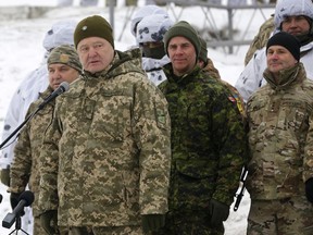Ukrainian President Petro Poroshenko, second left, addresses Ukrainian soldiers as Canadian Army Lieutenant General Jean-Marc Lanthier stands at center, and commander of U.S. Army in Europe Christopher Cavoli stands right, during military drills in base Honcharivske, Chernihiv region, Ukraine, Monday, Dec. 3, 2018. Ukraine's president announced a partial call-up of reservists for training amid tensions with Russia, saying Monday that the country needs to beef up its defenses to counter the threat of a Russian invasion.