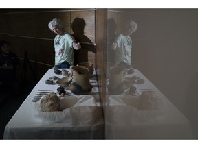 Archeologist Angela Rabelo shows artifacts rescued from the ashes of the fire that swept through Rio's National Museum in September, during a media presentation, in Rio de Janeiro, Brazil, Monday, Dec. 10, 2018. The director of the National Museum and the German consul hosted the press conference to announce their partnership for the reconstruction of the museum.