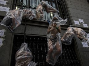 Women hanging in plastic bags perform during a protest against gender violence in Buenos Aires, Argentina, Wednesday, Dec. 5, 2018. Argentine feminist groups and labor unions are protesting a court ruling that acquitted two men accused of sexually abusing and killing a 16-year-old girl.