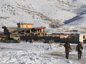 Afghan security forces walks near a site after a car bomb attack on a military base in the central province of Maidan Wardak on January 21, 2019.