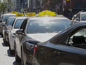 Taxi drivers line up awaiting fares in front of Union Station in Toronto , on Thursday July 2, 2015.
