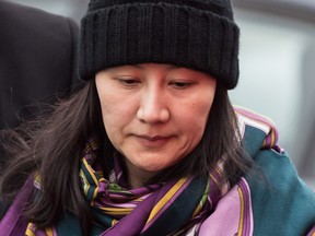 Huawei chief financial officer Meng Wanzhou is escorted by her private security detail while arriving at a parole office, in Vancouver, on Dec. 12, 2018.