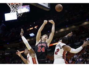 Chicago Bulls forward Lauri Markkanen (24) loses control of the ball as Miami Heat guard Josh Richardson, left, and guard Wayne Ellington (2) defend during the first half of an NBA basketball game, Wednesday, Jan. 30, 2019, in Miami.